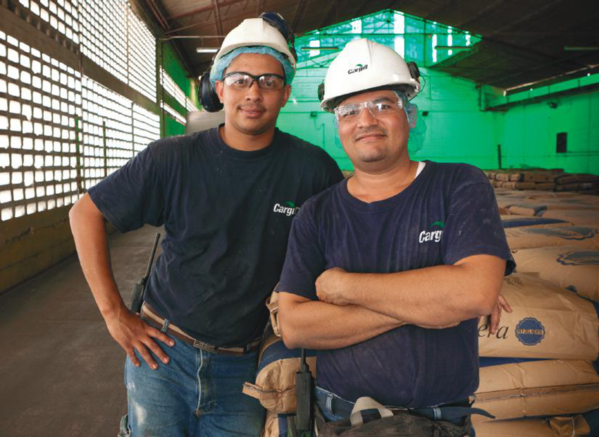 Dua karyawan pria sedang mengenakan pelindung kepala di sebuah gudang