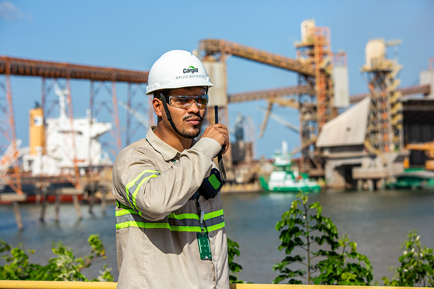 A male employee talking on a radio in a shipyard