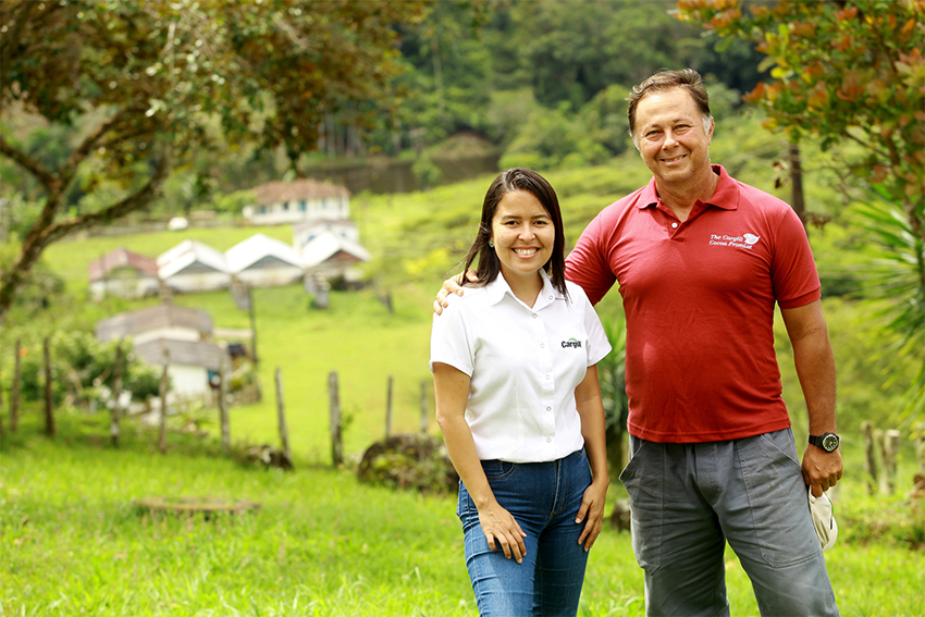 Một người đàn ông và một người phụ nữ tươi cười tạo dáng chụp ảnh trên cánh đồng