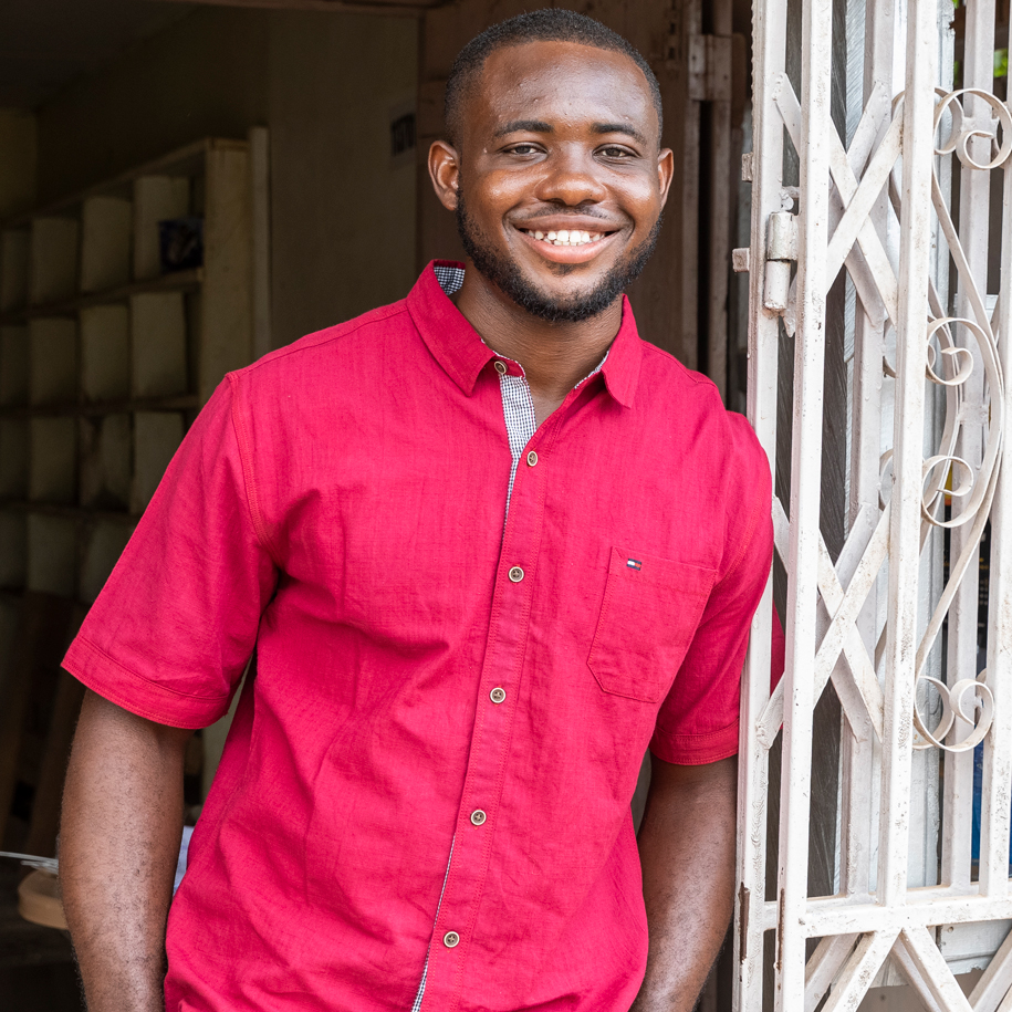 A smiling man leaning on a gate